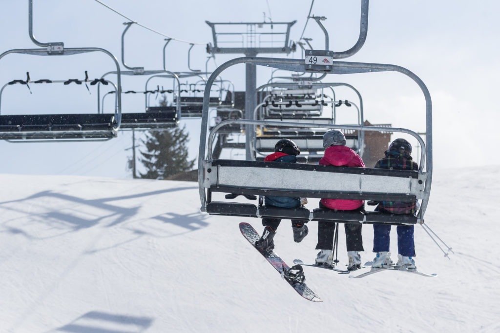 three kids on a ski lift