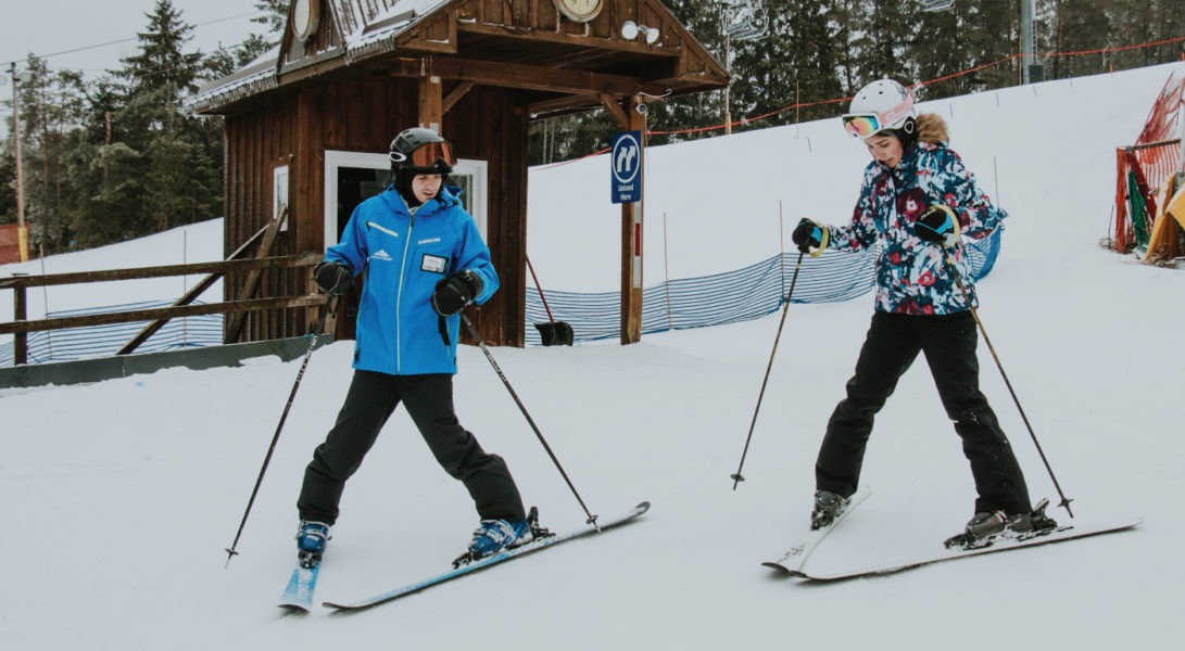 An instructor teaching a new skier