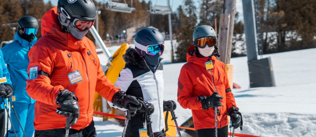 three skiiers stand together