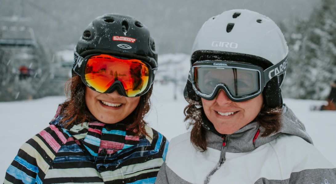Two skiers smiling at the camera