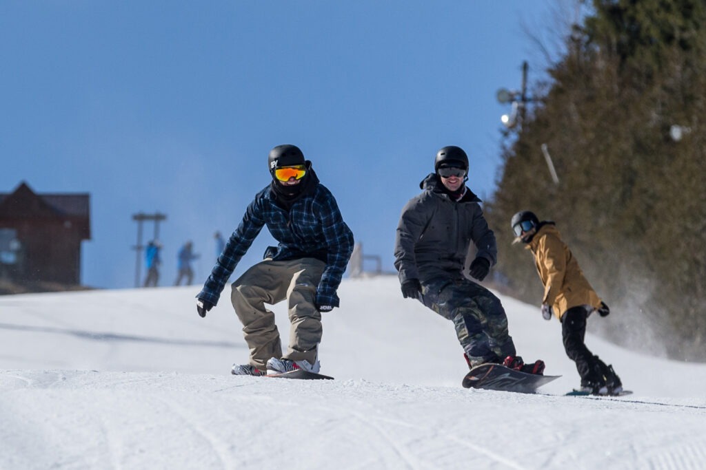 Three Snowboarders going down Standard Run